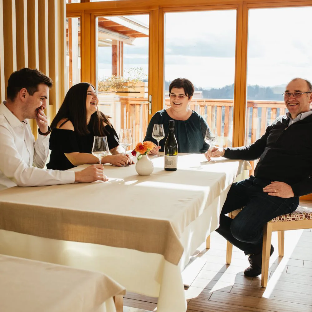 Die Familie Valdhuber am Tisch mit Blick in die Weingärten